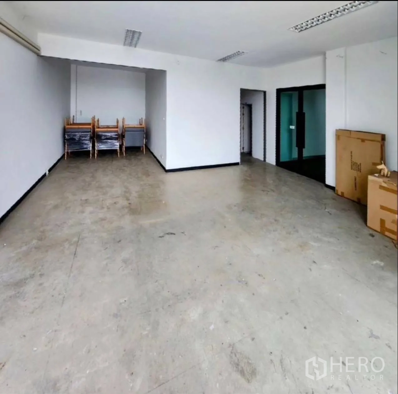 工厂 出租在Samut Prakan - 一层办公室或展厅，混凝土地面与日光灯照明。