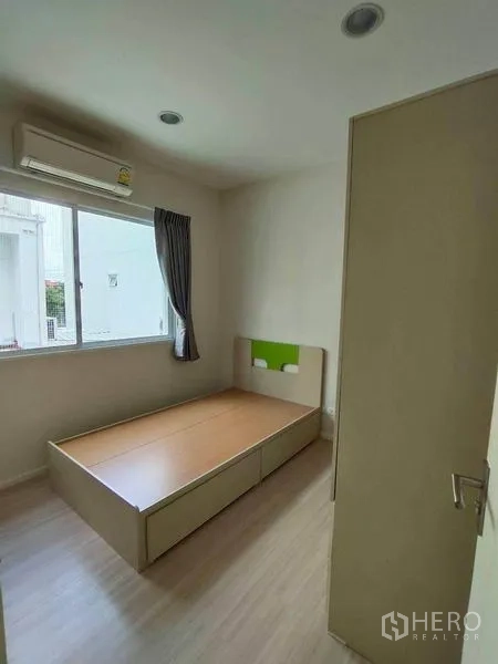 联排别墅 出租在Wang Thonglang, Bangkok - 次卧紧凑，带平台床、窗户、窗帘与壁挂空调。