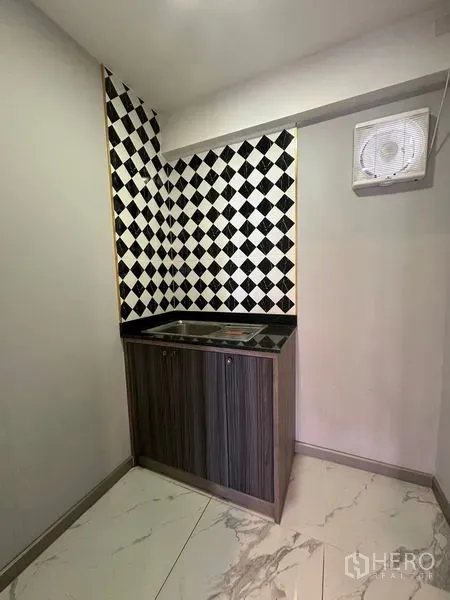 零售空间 出租在Bang Na, Bangkok - 小型茶水间，带水槽与柜体，黑白棋盘格墙面，方便员工使用。