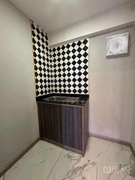 零售空间 出租在Bang Na, Bangkok - 小型茶水间，带水槽与柜体，黑白棋盘格墙面，方便员工使用。