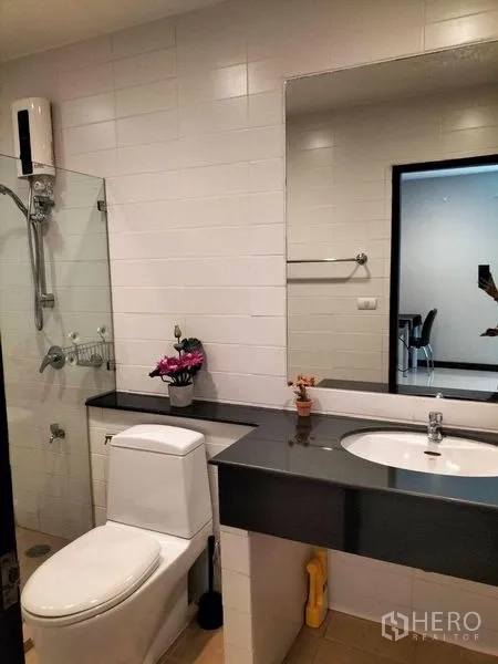 คอนโด ให้เช่าในWatthana, Bangkok - ห้องน้ำมีเคาน์เตอร์อ่างล้างหน้า กระจกบานใหญ่ ข้างฉากกั้นอาบน้ำและโถสุขภัณฑ์