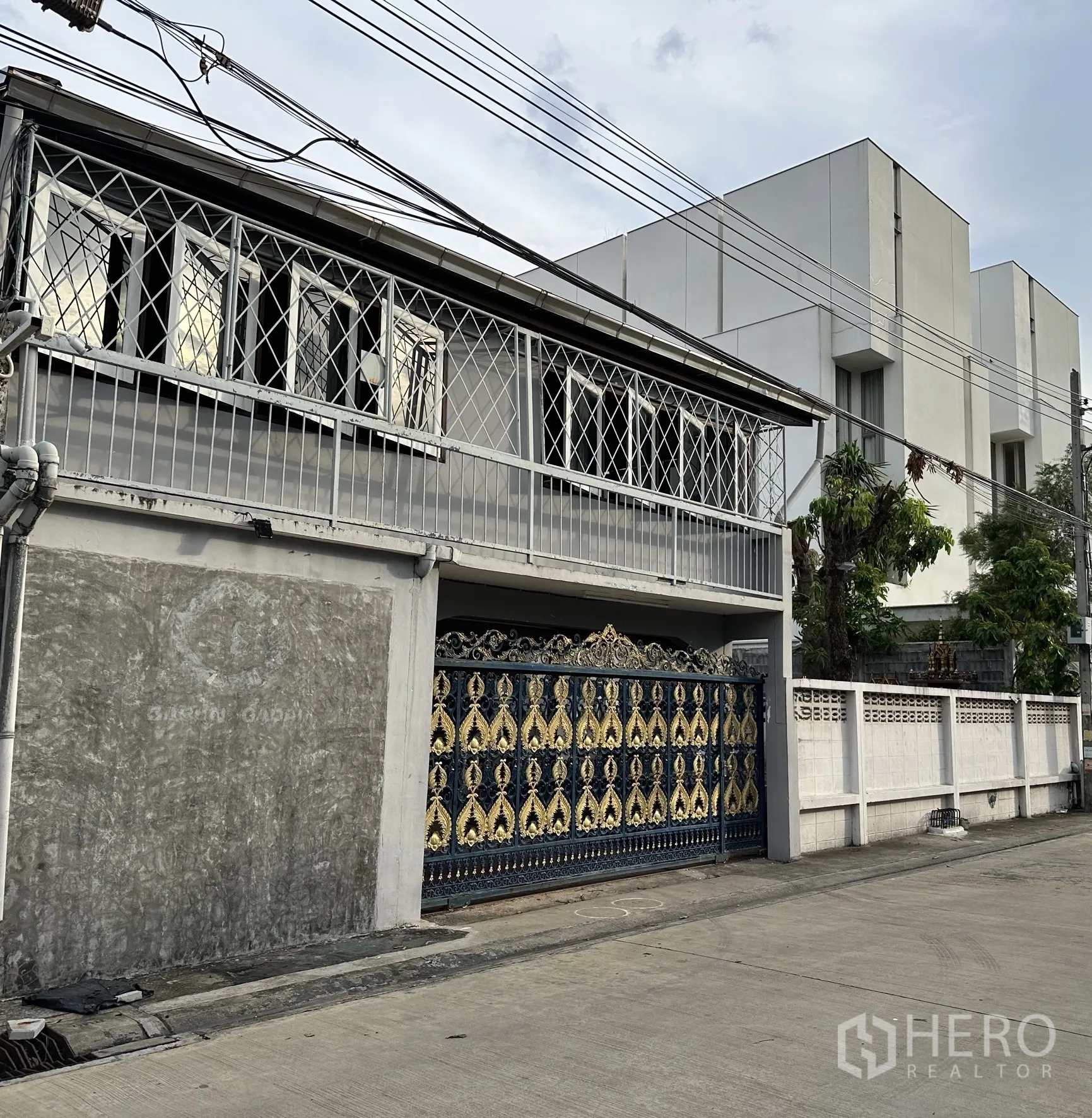 โฮมออฟฟิศ for rent in Suan Luang, Bangkok - มุมมองด้านข้างตัวบ้าน พร้อมประตูเหล็กลายทองน้ำเงินและเหล็กดัดหน้าต่าง