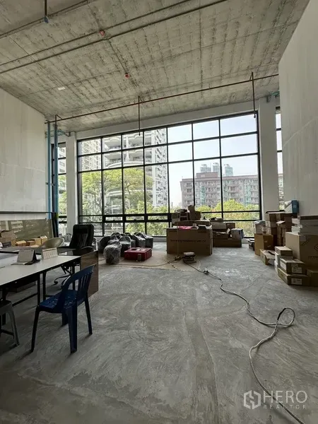 Retail Space for rent in Khlong Toei, Bangkok - Bright retail area with full-height windows facing greenery and city views, ideal for showroom or storefront.