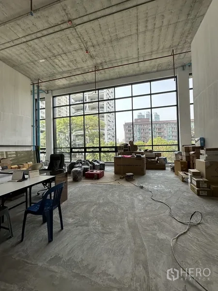 Retail Space for rent in Khlong Toei, Bangkok - Bright retail area with full-height windows facing greenery and city views, ideal for showroom or storefront.