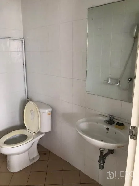 Factory for rent in Lam Luk Ka, Pathum Thani - Clean tiled restroom with toilet, basin and wall mirror inside the factory.