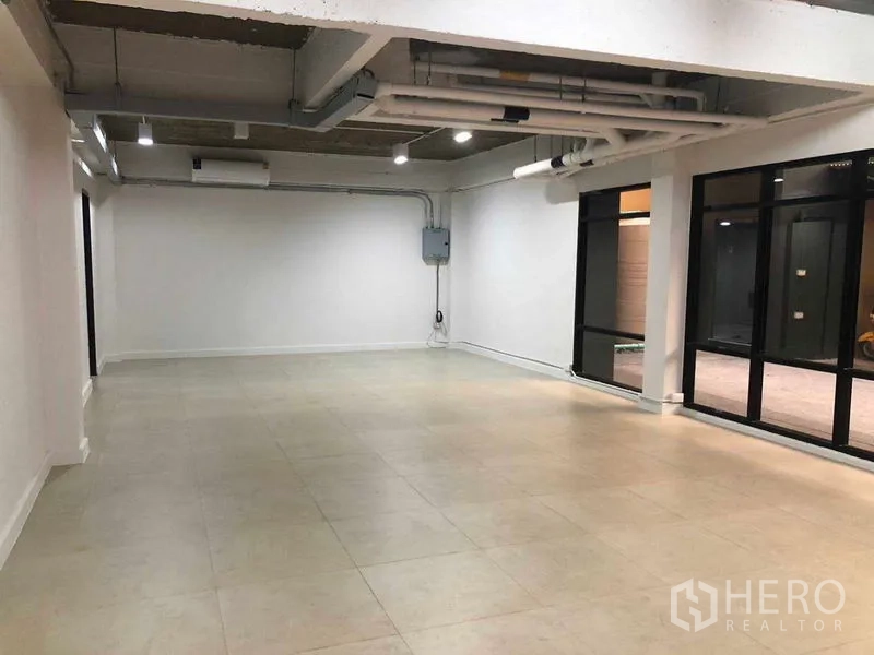 办公空间 出租在Phaya Thai, Bangkok - 宽敞室内，黑框玻璃门与工业风天花及射灯。