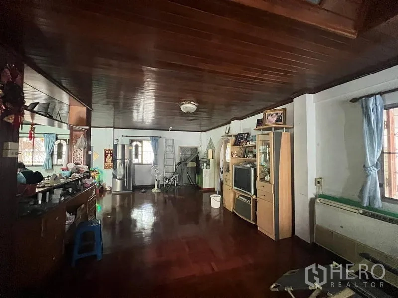 บ้าน ขายในPhra Khanong, Bangkok - ห้องนั่งเล่นกว้าง เพดานและพื้นไม้ หน้าต่างหลายบาน พร้อมตู้วางทีวี