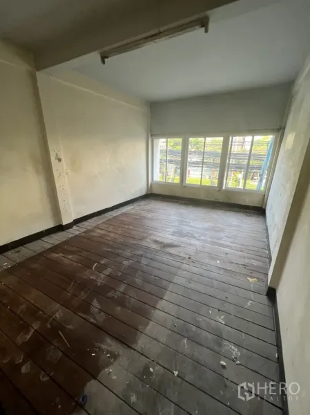 店屋 出租在Watthana, Bangkok - 楼上房间配大窗与旧木地板，空间空置，适合翻新。