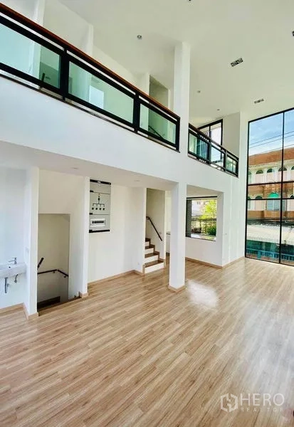 Home Office for sale in Wang Thonglang, Bangkok - Light-filled atrium-style space with mezzanine railing and floor-to-ceiling glazing.