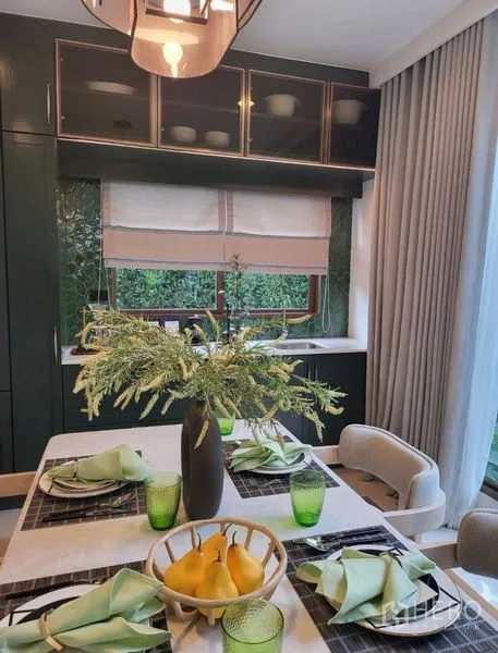 Detached House for rent in Bang Kapi, Bangkok - Cozy dining area with green cabinets, window to greenery and neatly set tableware.