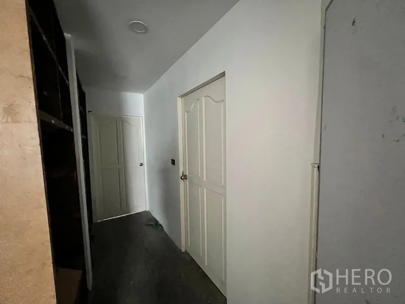 อาคารพาณิชย์ ให้เช่าในWatthana, Bangkok - ทางเดินภายในอาคารพร้อมประตูสีขาวไปยังห้องบริการต่าง ๆ.