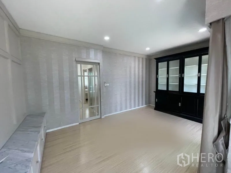 ทาวน์เฮาส์ ขายในSuan Luang, Bangkok - ห้องนั่งเล่นกว้าง พร้อมตู้โชว์กระจกและทางออกสู่ระเบียงผ่านประตูกระจก