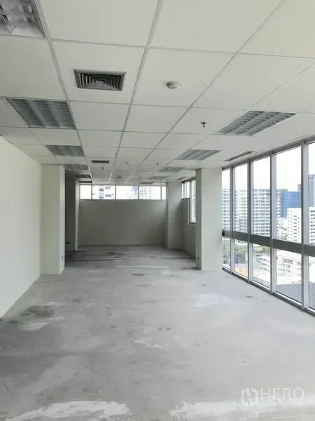 Office Space for rent in Khlong Toei, Bangkok - Long open office with full-length windows and city views along one side.