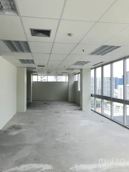 Office Space for rent in Khlong Toei, Bangkok - Long open office with full-length windows and city views along one side.