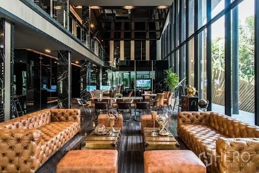 คอนโด ให้เช่าหรือขาย - ล็อบบี้หรูโซฟาหนังสีน้ำตาล ผนังกระจกโปร่งสูง