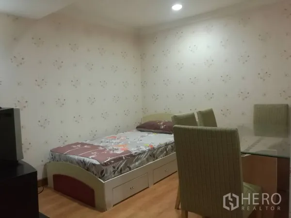 公寓 出租在Khlong Toei, Bangkok - 次卧带单人床与抽屉收纳，旁有玻璃餐桌。