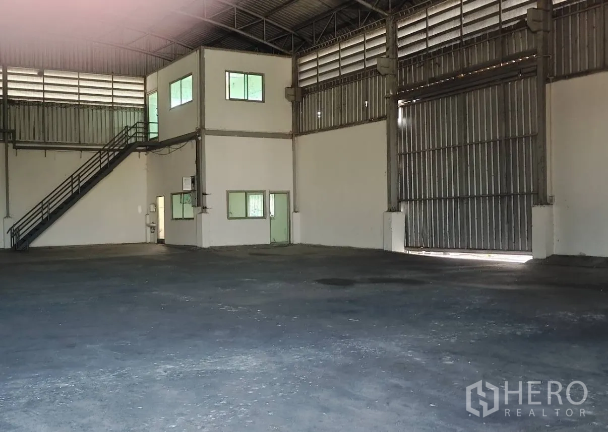 工厂 出租在Lat Lum Kaeo, Pathum Thani - 宽敞厂房内景，带两层办公室、金属楼梯和大型滑动门。