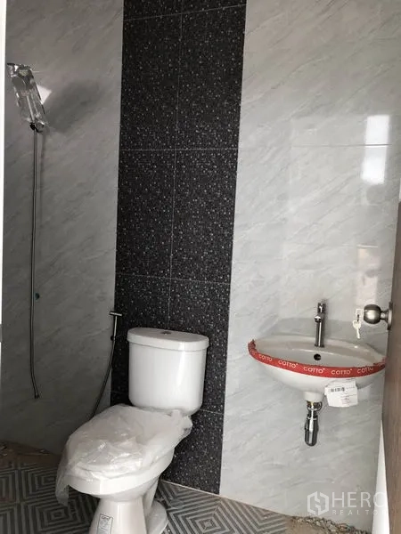 工厂 出租或出售在Sai Noi, Nonthaburi - 新安装的卫生间，贴墙砖，配坐便器、手持花洒与小洗手盆。