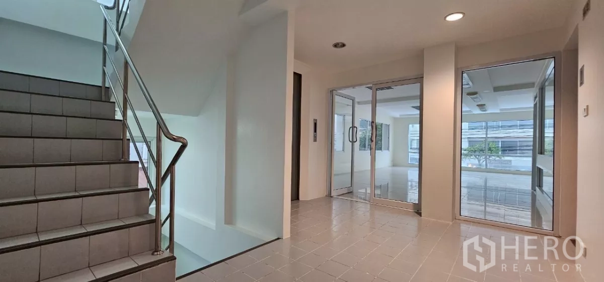 Office Space for rent in Bueng Kum, Bangkok - Stair landing with stainless railing and glass entry doors beside the elevator.