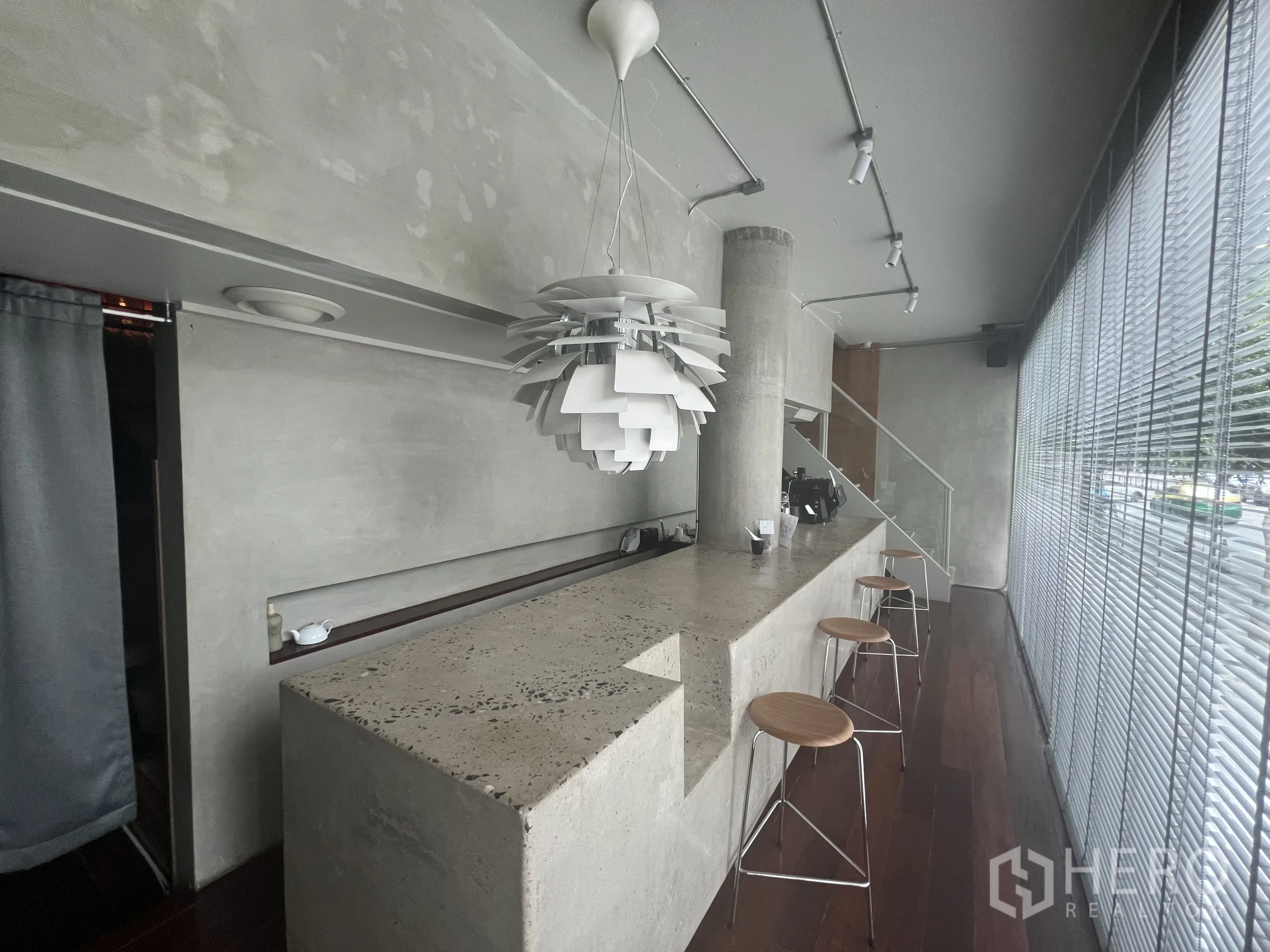 零售空间 出租在Watthana, Bangkok - 临街咖啡吧台，清水混凝土风格、吧凳与落地百叶。