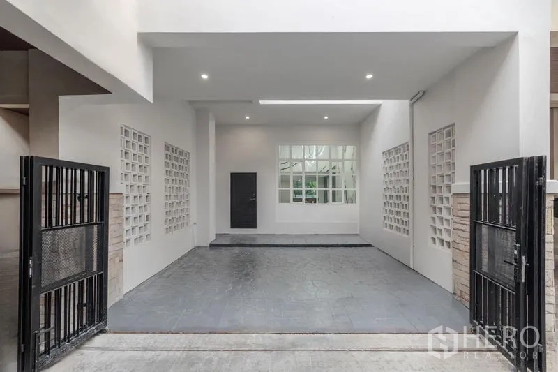 ทาวน์เฮาส์ ขาย - ที่จอดรถในร่มสำหรับสองคัน พร้อมประตูรั้วเลื่อนสีดำและไฟดาวน์ไลท์