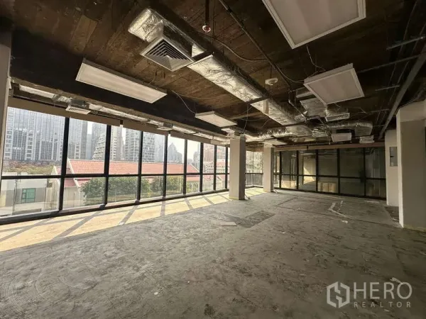 办公空间 出租 - 明亮的80平方米办公区，环幕玻璃与吊灯照明，临近BTS奇隆站的城市景观。
