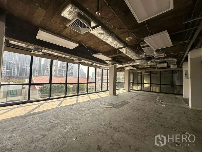 办公空间 出租 - 明亮的80平方米办公区，环幕玻璃与吊灯照明，临近BTS奇隆站的城市景观。