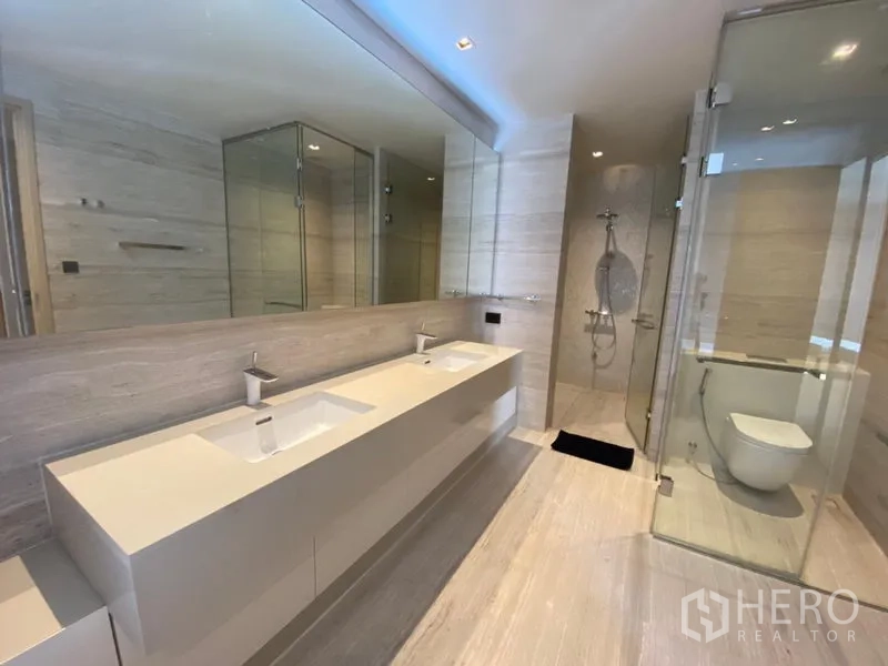 Detached House for rent in Huai Khwang, Bangkok - Master bathroom with double vanity, large mirror, glass shower and separate toilet cubicle.