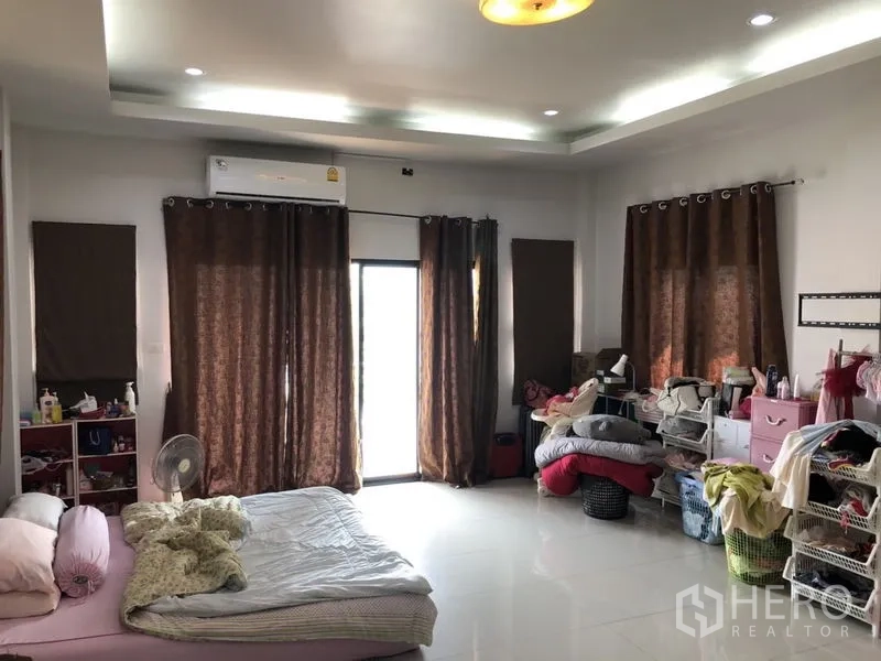 บ้าน ขายในLam Luk Ka, Pathum Thani - อีกมุมของห้องนอนกว้างพร้อมผ้าม่านสีน้ำตาลและพื้นเงา