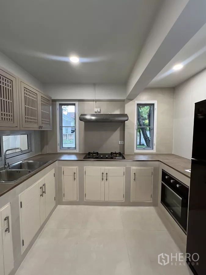 Detached House for rent in Saphan Sung, Bangkok - U-shaped kitchen counter with twin sinks, gas burners and extractor hood.