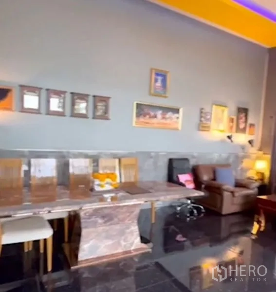 Detached House for sale in Bang Bua Thong, Nonthaburi - Marble dining table against a gray accent wall decorated with framed artworks.