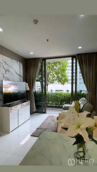 Condominium for rent in Sathon, Bangkok - Open‑plan living room viewed from marble dining counter with city backdrop.