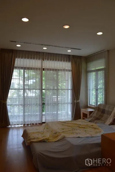 Detached House for rent or sale in Bang Phli, Samut Prakan - Bedroom featuring full‑height windows, curtains and garden views.