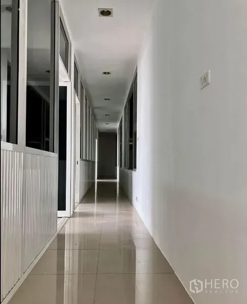 货栈 出租在Prawet, Bangkok - 铺设瓷砖的走廊，左右为玻璃隔断办公间。