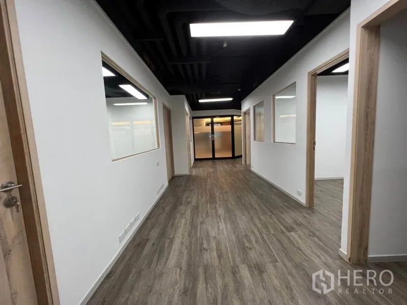 办公空间 出租在Khlong Toei, Bangkok - 单元内长走廊，多间房与玻璃窗板，通向入口