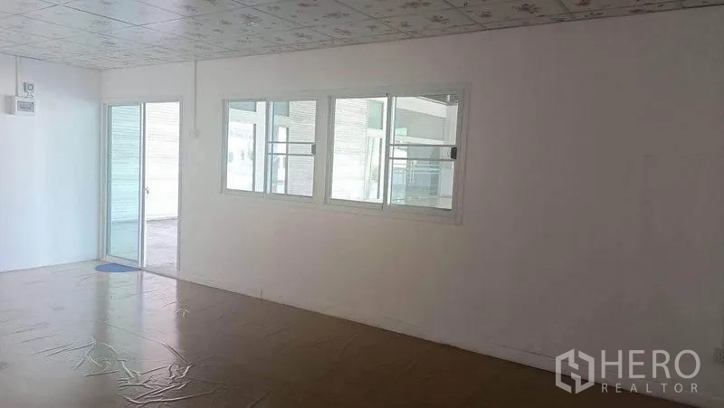 Warehouse for rent in Bang Phli, Samut Prakan - Office zone with sliding glass door and windows opening to the covered loading platform.