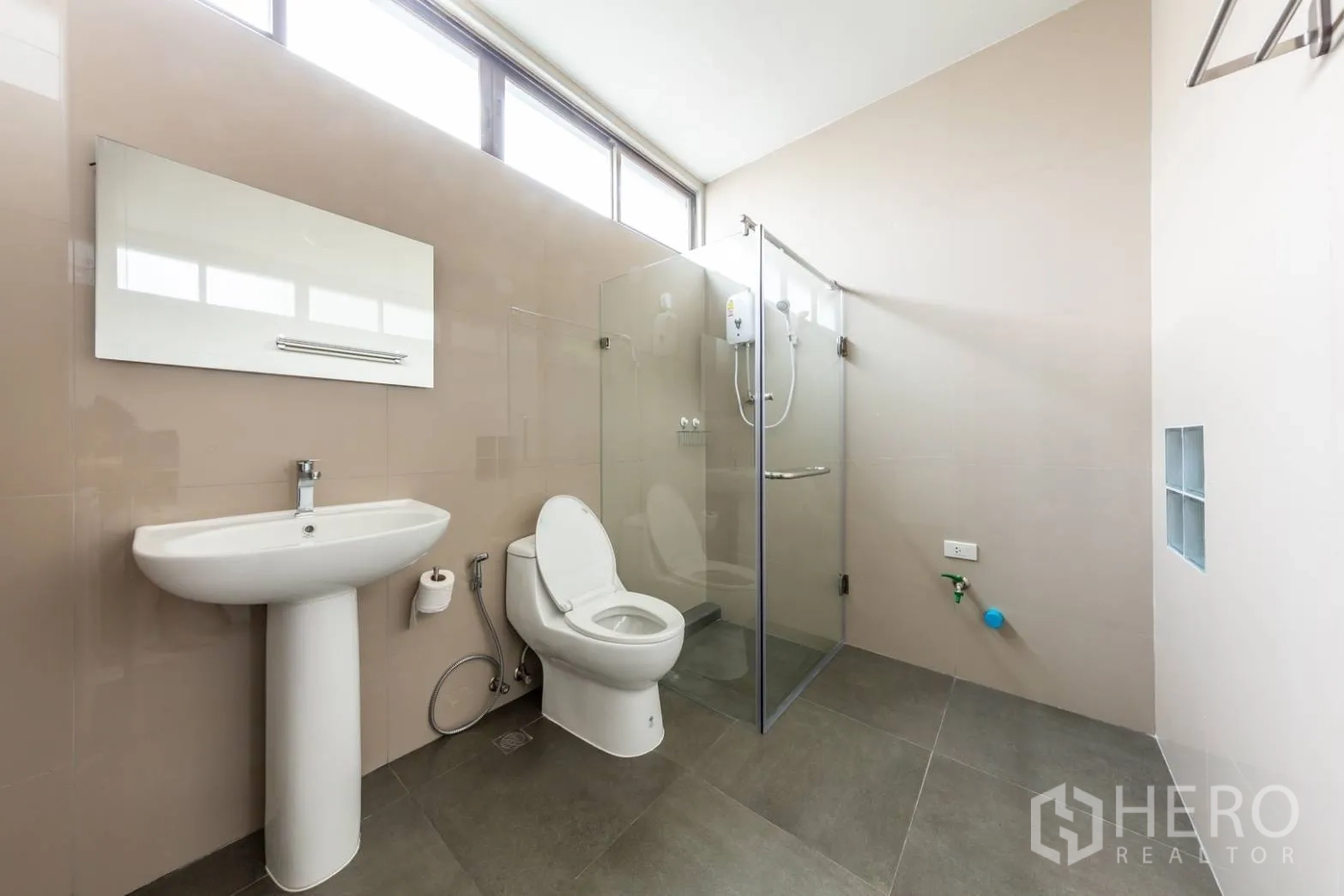 带办公室的家 出租在Bang Rak, Bangkok - 采光充足的卫浴，高窗与玻璃淋浴间。