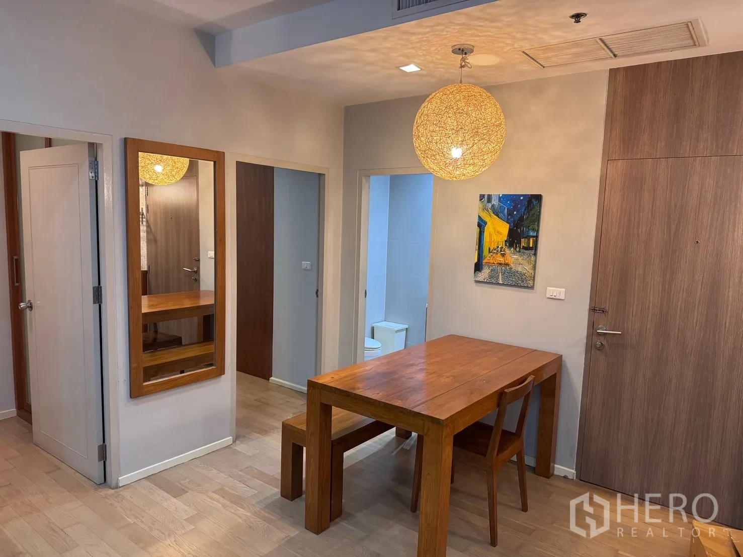 คอนโด for rent or sale in Watthana, Bangkok - มุมทานอาหารโต๊ะไม้พร้อมม้านั่ง กระจกเงาบานใหญ่ โคมไฟแขวน และประตูทางเข้า