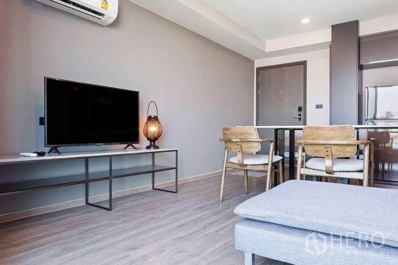 Condominium for rent or sale in Watthana, Bangkok - Bright living room with TV console, seating and wood-style flooring in an open layout.