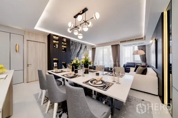 คอนโด ให้เช่าในWatthana, Bangkok - ห้องนั่งเล่นและรับประทานอาหารแบบเปิดโล่ง โคมไฟดีไซน์หรู ผนังลายหินอ่อน และหน้าต่างสูงเต็มบานในคอนโดใกล้อโศก