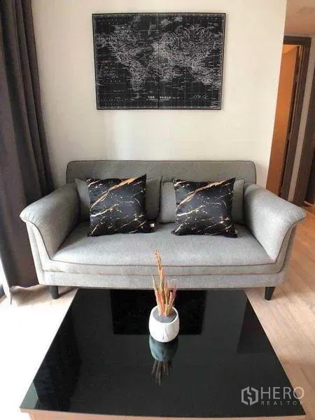 คอนโด ให้เช่าในWatthana, Bangkok - โซฟาสีเทาพร้อมหมอนลายหินอ่อนและโต๊ะกลางกระจกสีดำ ในมุมนั่งเล่น