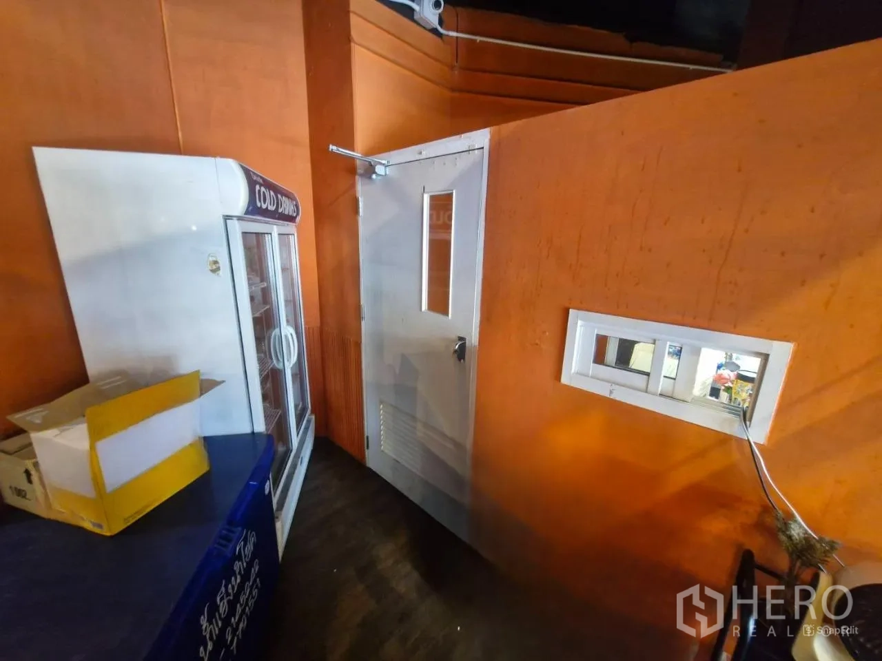 Shophouse for rent in Pathum Wan, Bangkok - Service zone with walk-in cold room door beside display fridge.
