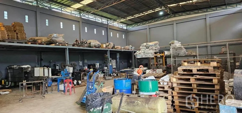Warehouse for rent in Bang Kruai, Nonthaburi - Spacious warehouse hall with steel roof, mezzanine platform and pallet stacks.