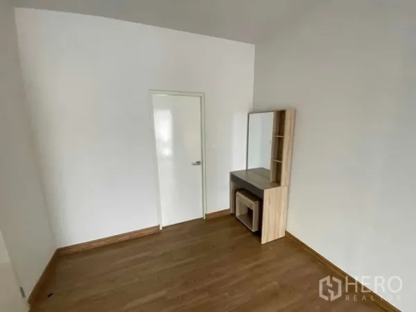 联排别墅 出租在Prawet, Bangkok - 极简卧室，木地板，带镜子的梳妆台。