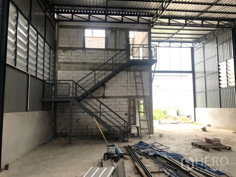 คลังสินค้า ให้เช่าในLam Luk Ka, Pathum Thani - ภายในโกดังเพดานสูง เห็นบันไดและชั้นลอย พร้อมแผ่นรับแสง