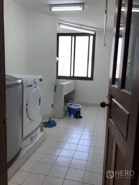 Condominium for rent in Watthana, Bangkok - Separate laundry room with washer, dryer and utility sink by a window.