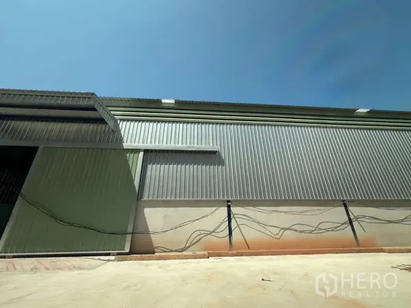 คลังสินค้า ให้เช่าในLat Krabang, Bangkok - ผนังภายนอกเมทัลชีทของโกดัง พร้อมลานคอนกรีตและเดินสายสาธารณูปโภค