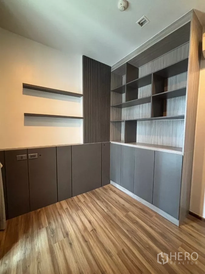 Condominium for rent or sale in Watthana, Bangkok - Second bedroom or study featuring extensive built-in shelving and cabinets.