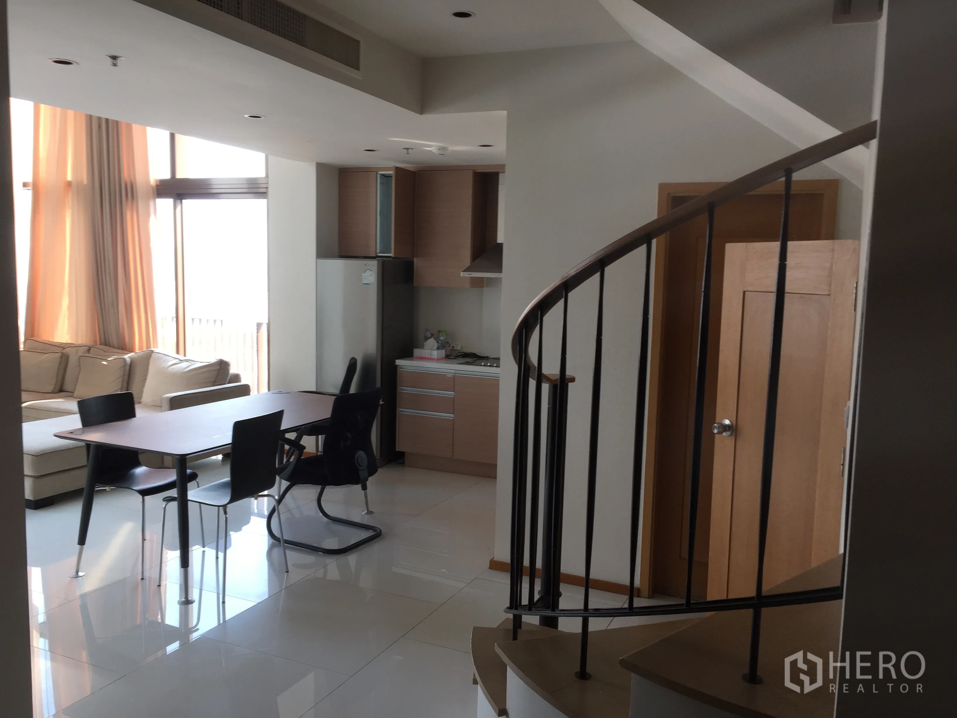 คอนโด ให้เช่าหรือขายในKhlong Toei, Bangkok - พื้นที่นั่งเล่นและรับประทานอาหารแบบโอเพ่น พร้อมบันไดเวียน ครัวขนาดกะทัดรัด และหน้าต่างบานใหญ่