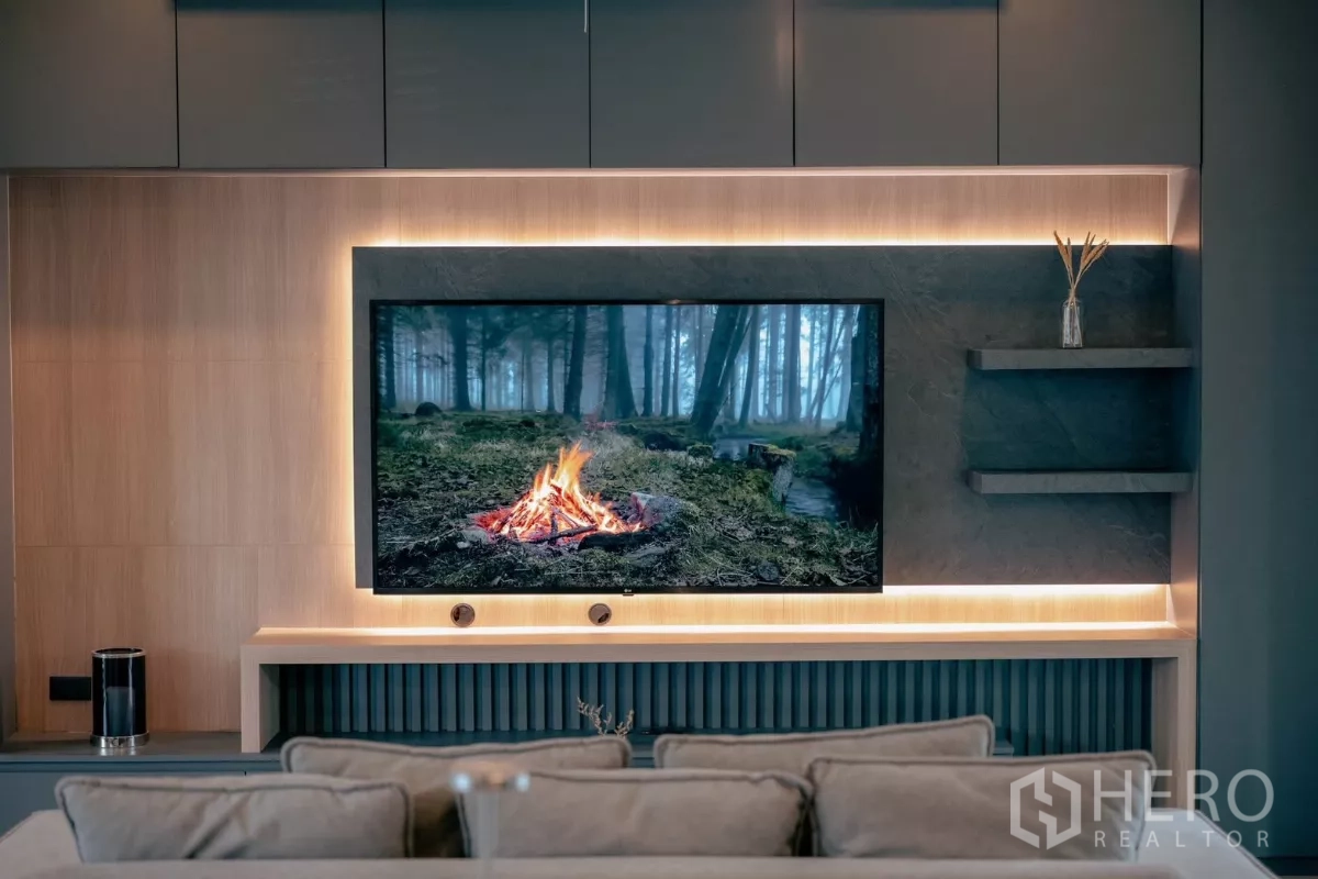 独立式住宅 出租或出售在Bang Phli, Samut Prakan - 客厅电视背景墙，木饰面与暖色灯带。